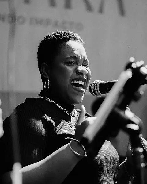 Cantora da Black SP rindo ao microfone